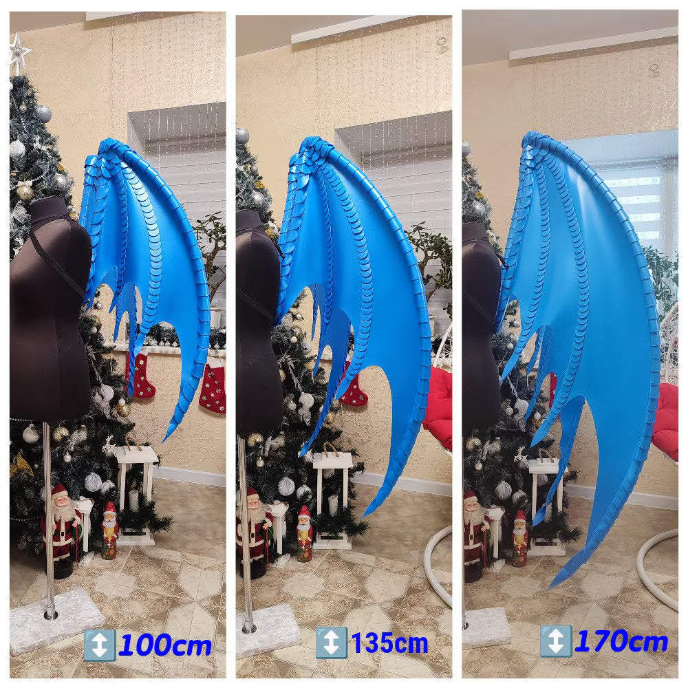 Blue dragon wings displayed on a mannequin in front of a Christmas tree.