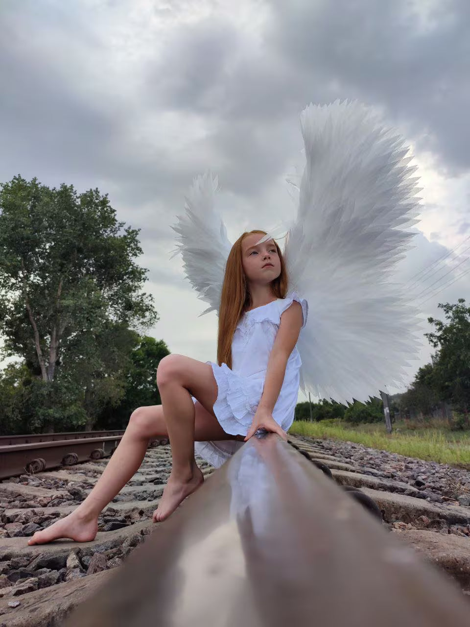 Large wearable white angel wings with adjustable straps, handmade from individually hand-cut foam feathers for cosplay and photoshoots