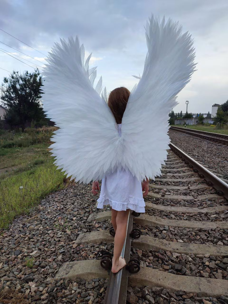 Elegant white angel wings crafted from foamed polyethylene with realistic hand-cut feathers for Halloween and cosplay.